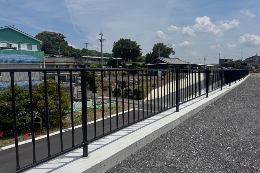 歩道に設置された黒い防護柵の写真